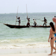 Tourists walk along the beach in Mombasa